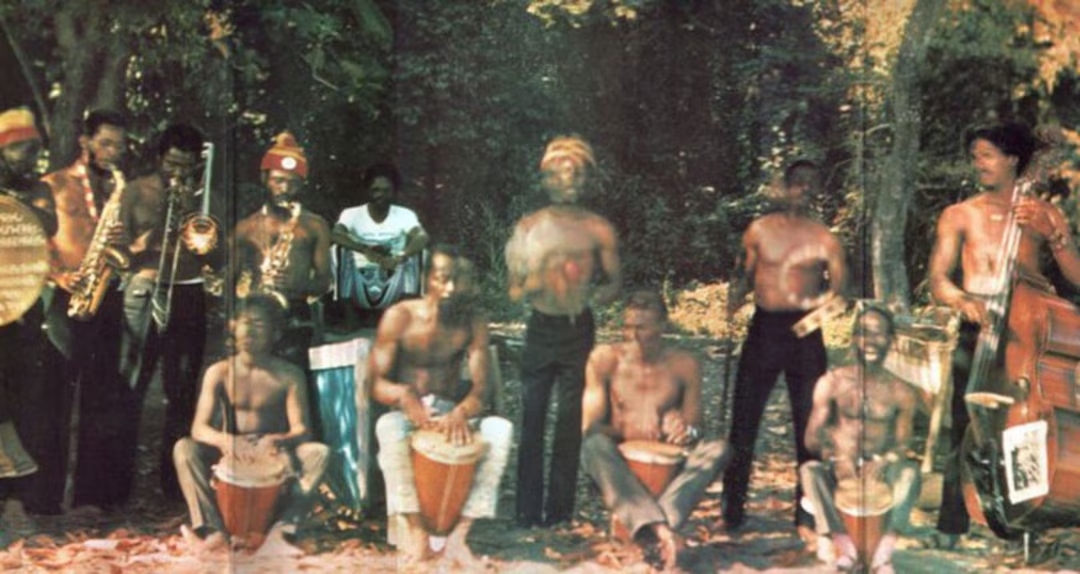 Count Ossie and the Mystic Revelation of Rastafari, a pioneering group in Jamaican music, performing with traditional Nyabinghi drummers and various musicians in an outdoor setting.