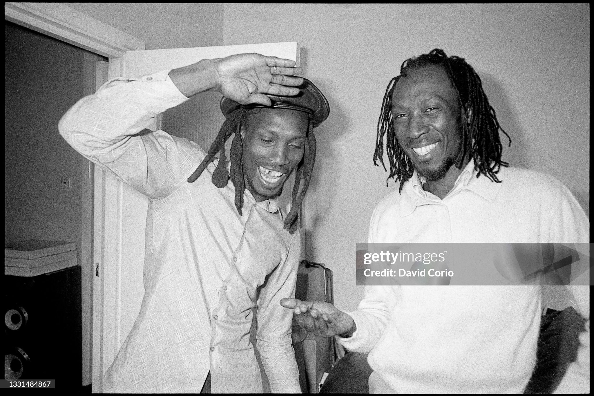 Trevor Bow and Alton Ellis sharing a light-hearted moment, captured in black and white, showcasing their camaraderie and influence on the reggae music scene. Photo by David Corio.